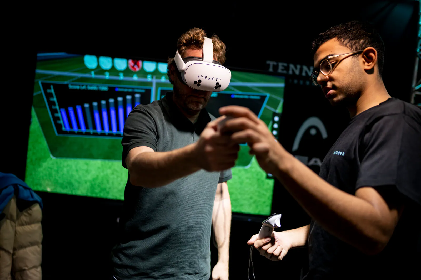 Spieler trainiert mit IMPROVR VR-Headset und Controllern, betreut von einem Coach, Trainingsdaten im Hintergrund